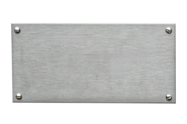 Distressed stainless steel plaque with a brush silver metal texture and screws cut out and isolated on a white background Distressed stainless steel plaque with a brush silver metal texture and screws cut out and isolated on a white background, signage stock photo image bronze plaque texture stock pictures, royalty-free photos & images