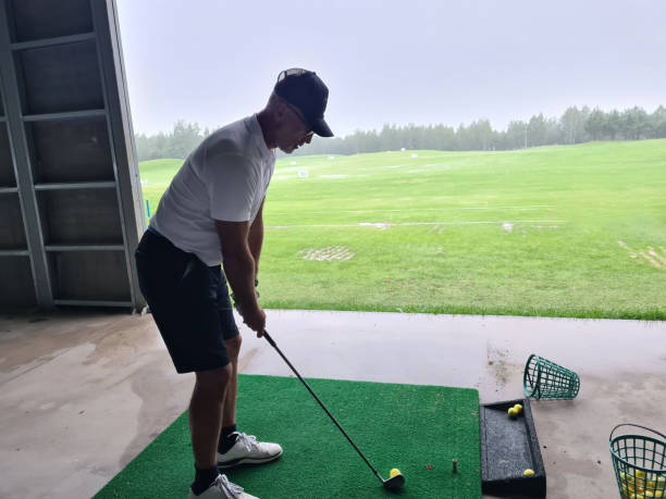 istock A golfer practices his swing at a driving range under overcast skies, showcasing focus and determination despite the rain 2174683131