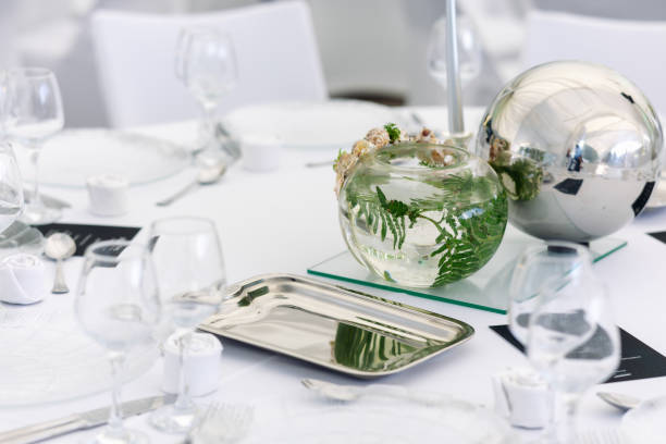 istock Elegant table setting featuring a glass vase with greenery and a decorative metal orb at a sophisticated dining event 2174685018