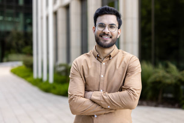istock Smiling young professional standing confidently outdoors in smart casual attire, exuding positivity and modern business vibes 2174690584