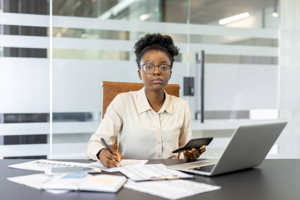 istock Serious financier calculating numbers with a calculator and laptop in modern office setting for financial analysis 2174691764