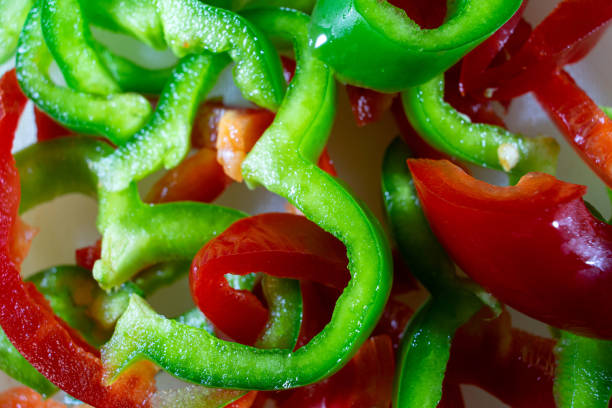 Thin slices of fresh green pepper on white background