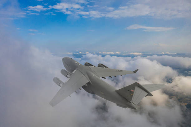 istock US Air Force C-17 Globemaster III transport aircraft. Flying over clouds. 2174693719
