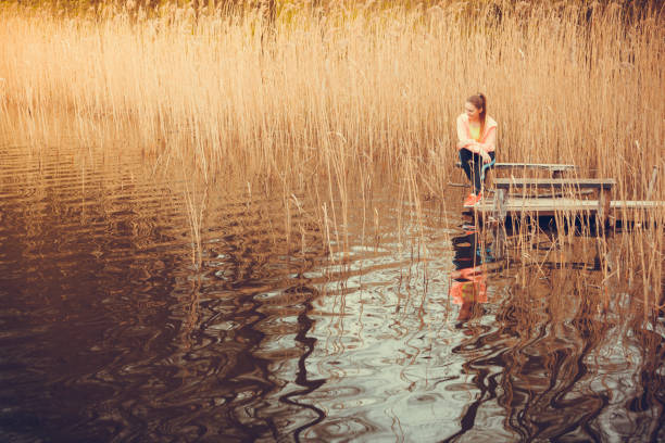 Reflective moment during sunset, young girl with long hair