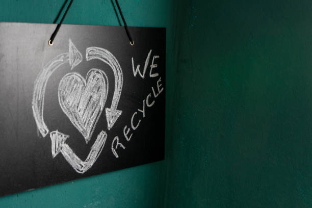 A slate board featuring a creative recycling symbol with a heart at its center, accompanied by the text \