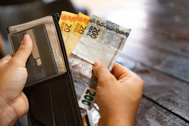 istock Human hand taking real bills out of wallet 2174696651
