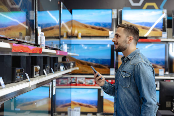 istock Man shopping for a new television in electronics store 2174699207