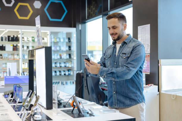 Handsome man shopping for a new smartphone in an electronics store