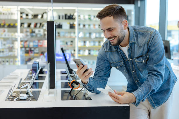 istock Handsome man shopping for a new smartphone in an electronics store 2174699315