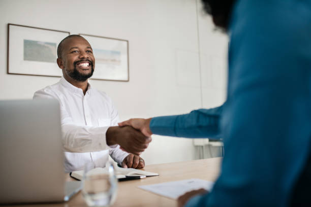 istock Smiling office manager shaking hands with a new employee 2174702988