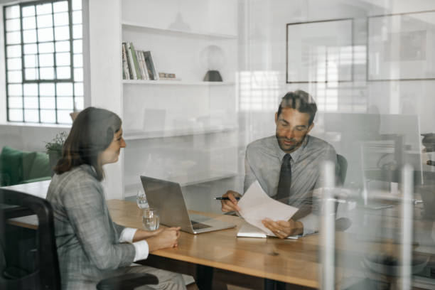 istock Smiling manager reading an applicant's resume during an interview 2174703249