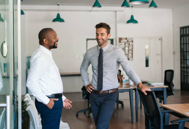 istock Two businessmen talking and laughing together in an office 2174704467