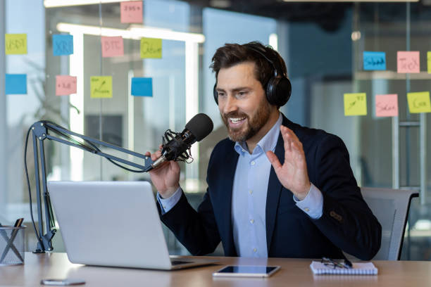 istock Professional podcaster engaging audience in studio with microphone and laptop during live broadcast 2174708072