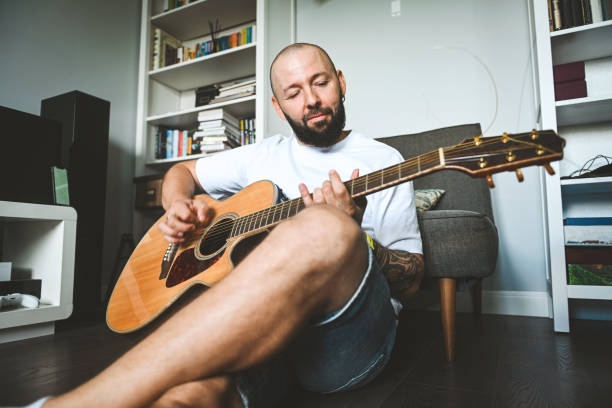 man plays the guitar and sings songs