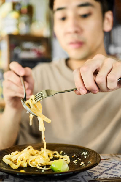 istock Young man eating a Thai noodles at a restaurant 2174718513