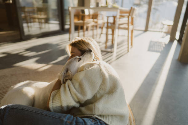 Photo of a young woman and her dog spending a winter day together in the cabin house