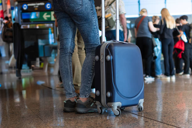istock Woman holding suitcase while waiting at airport 2174727622