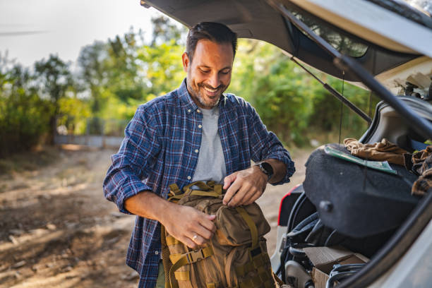istock Adult man take backpack from trunk ready for adventure in the forest 2174731416