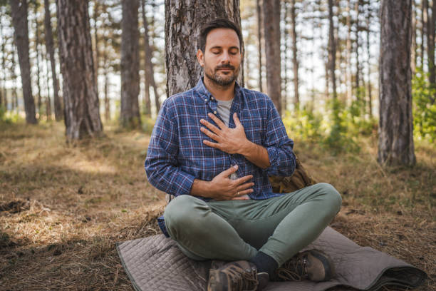 istock Adult man camper practice meditation and breath exercise in front tree 2174732155