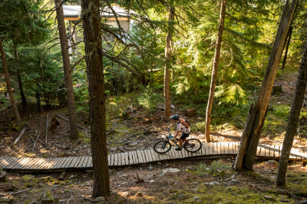 istock Young woman mountain biker rides across boardwalk 2174734097
