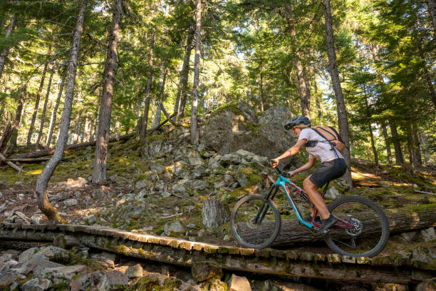 istock Young woman mountain biker rides across boardwalk 2174734128