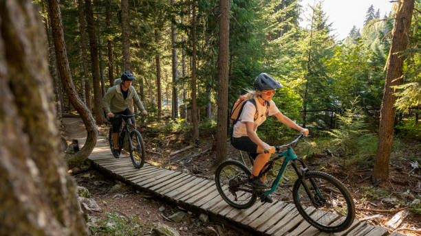 istock Mountain bikers ride across boardwalk through forest 2174734232