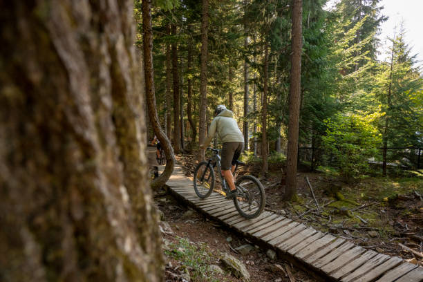 istock Young man mountain bikes across boardwalk 2174734367
