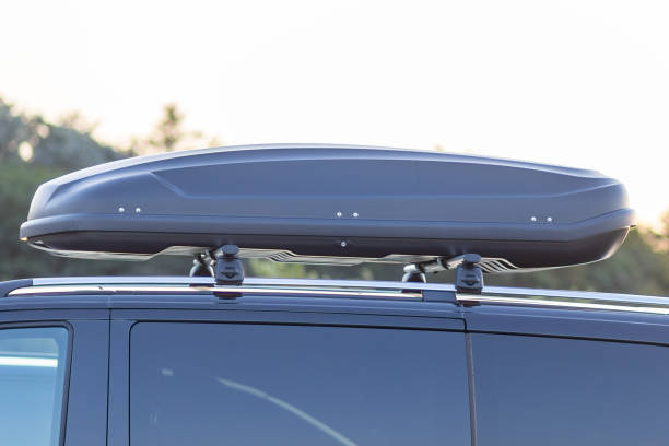 istock A sleek black rooftop cargo box mounted on a vehicle in a scenic outdoor setting during golden hour 2174737758