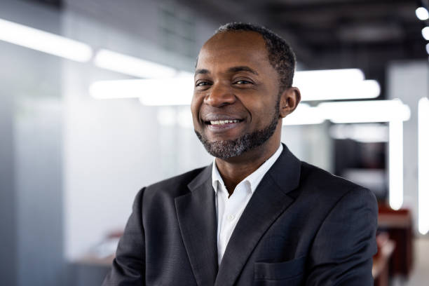 istock Confident businessman smiling in modern office environment with natural lighting, wearing elegant suit and white shirt, symbolizing success and professionalism, ready for business leadership opportunities 2174744177