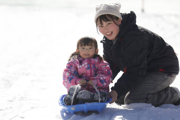 Parents and children playing on a sled