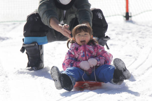 Parents and children playing on a sled