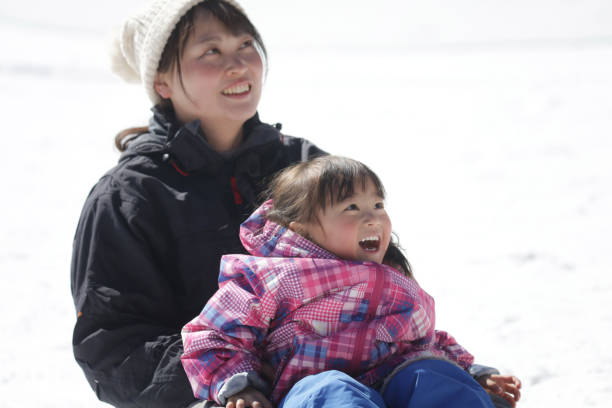 Little girl and boy enjoying sleigh ride. Child sledding. Brother and sister riding a sledge. Children play outdoors in snow. Kids sled in snowy park in winter. Outdoor fun for family vacation.