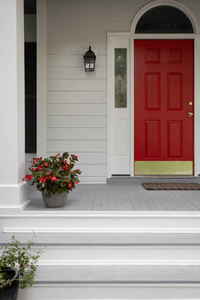 istock Red Door With Potted Plant On A Bright Front Porch 2174752115
