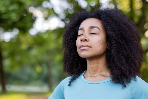 istock Peaceful woman practicing mindfulness in serene natural setting with closed eyes and relaxed expression, enjoying tranquility and connection with nature 2174753037