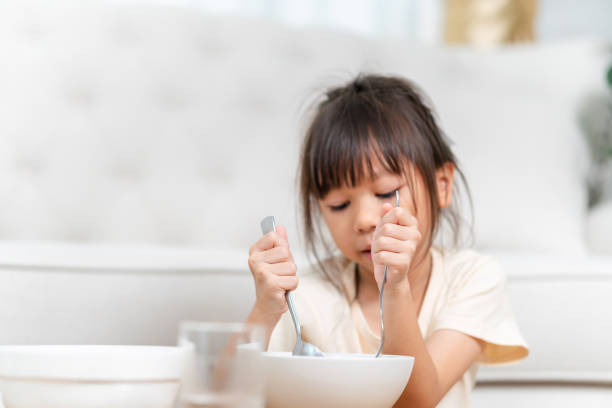 istock Asian kid girl having breakfast by herself 2174753973