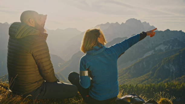 istock Male and Female Hikers Pausing to Admire Mountain View 2174757717