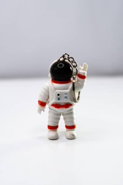 istock Cute astronaut keychain waving to the camera on a white background 2174765770