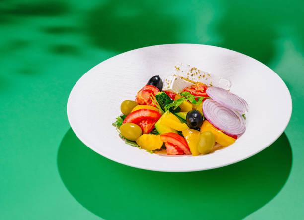 istock Greek salad on white plate with green background 2174772033