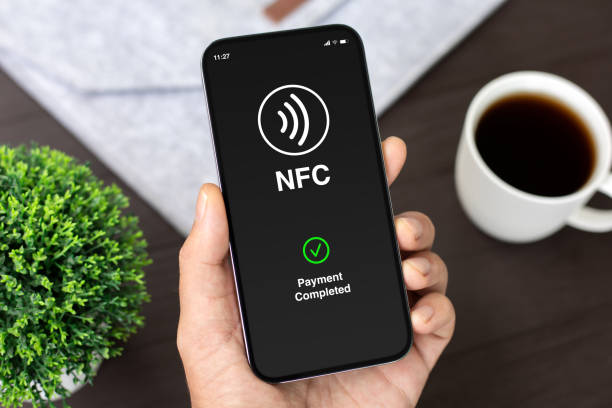 istock Male hand phone pay wireless technology nfc via pos terminal 2174774359