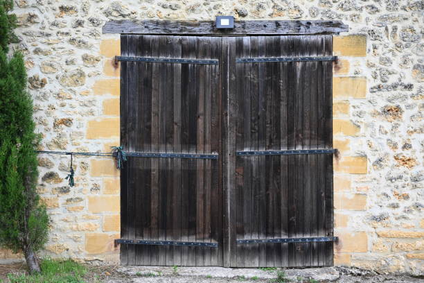 Old wooden barn doors surrounded by a limestone stone wall