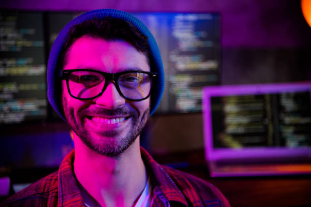 istock Photo of smiling cheerful guy dressed glasses hat game developing modern device indoors workstation workshop home 2174809084