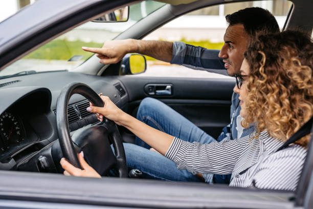 istock Young Woman Having A Driving Lesson With A Male Driving Instructor 2174811185
