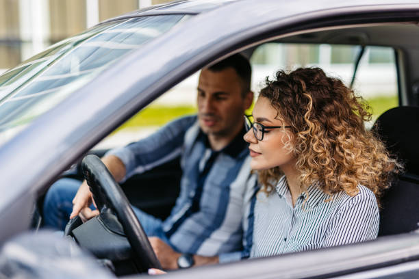 istock Young Woman Having A Driving Lesson With A Male Driving Instructor 2174812531