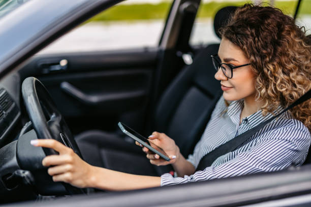 istock Young Woman Using Her Phone While Driving A Car 2174813365