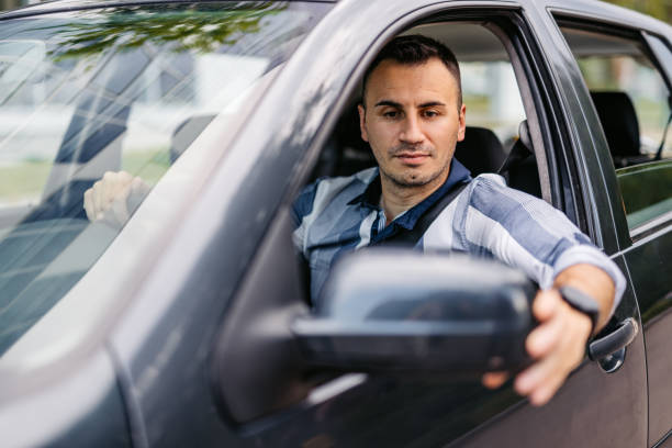 istock Mid-Adult Man Adjusting His Side-View Mirror In The Car 2174816412