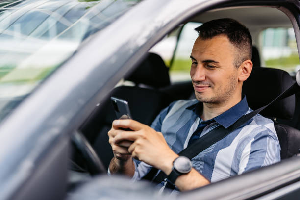 istock Mid-Adult Man Using His Phone While Driving A Car 2174816715