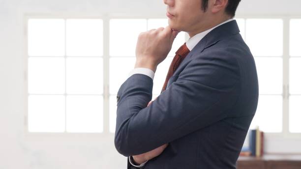 A worried businessman with his hand on his chin stock photo