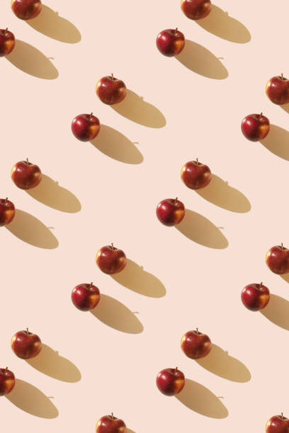 istock Red apples on light beige pastel background with long shadows. Apple Day 2174823904