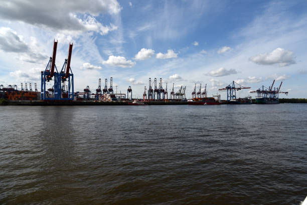 Port of Hamburg Container Terminal. The image shows several container cranes loading container ships. The image was captured during spring season.