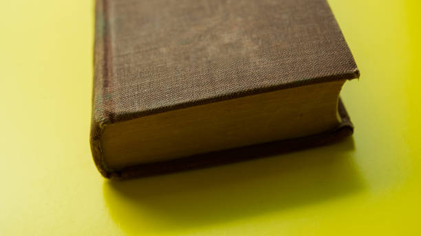 istock One old book lies on a yellow background, close-up. 2174837176
